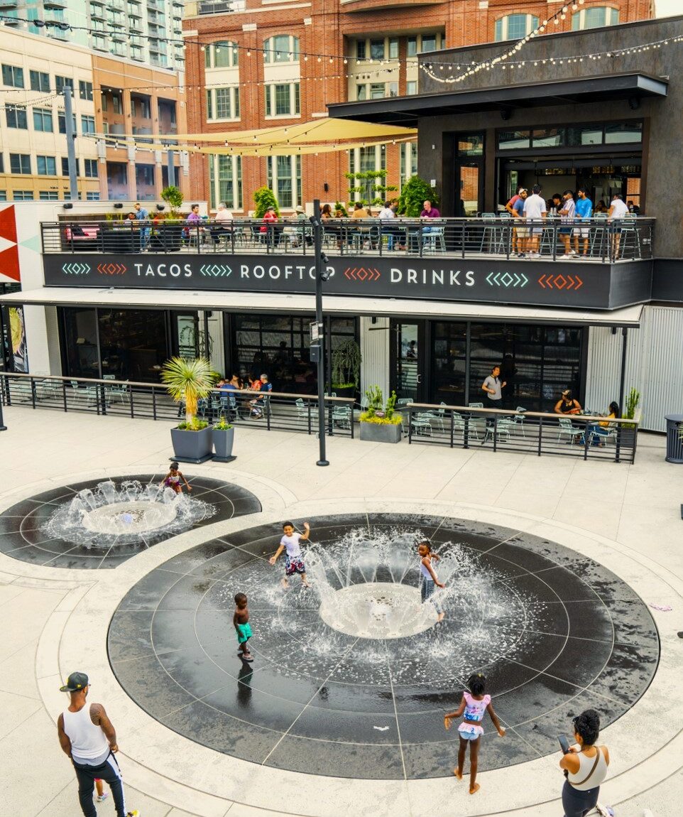 kids playing in splash pad fountains outside of a restaurant in Atlantic Station
