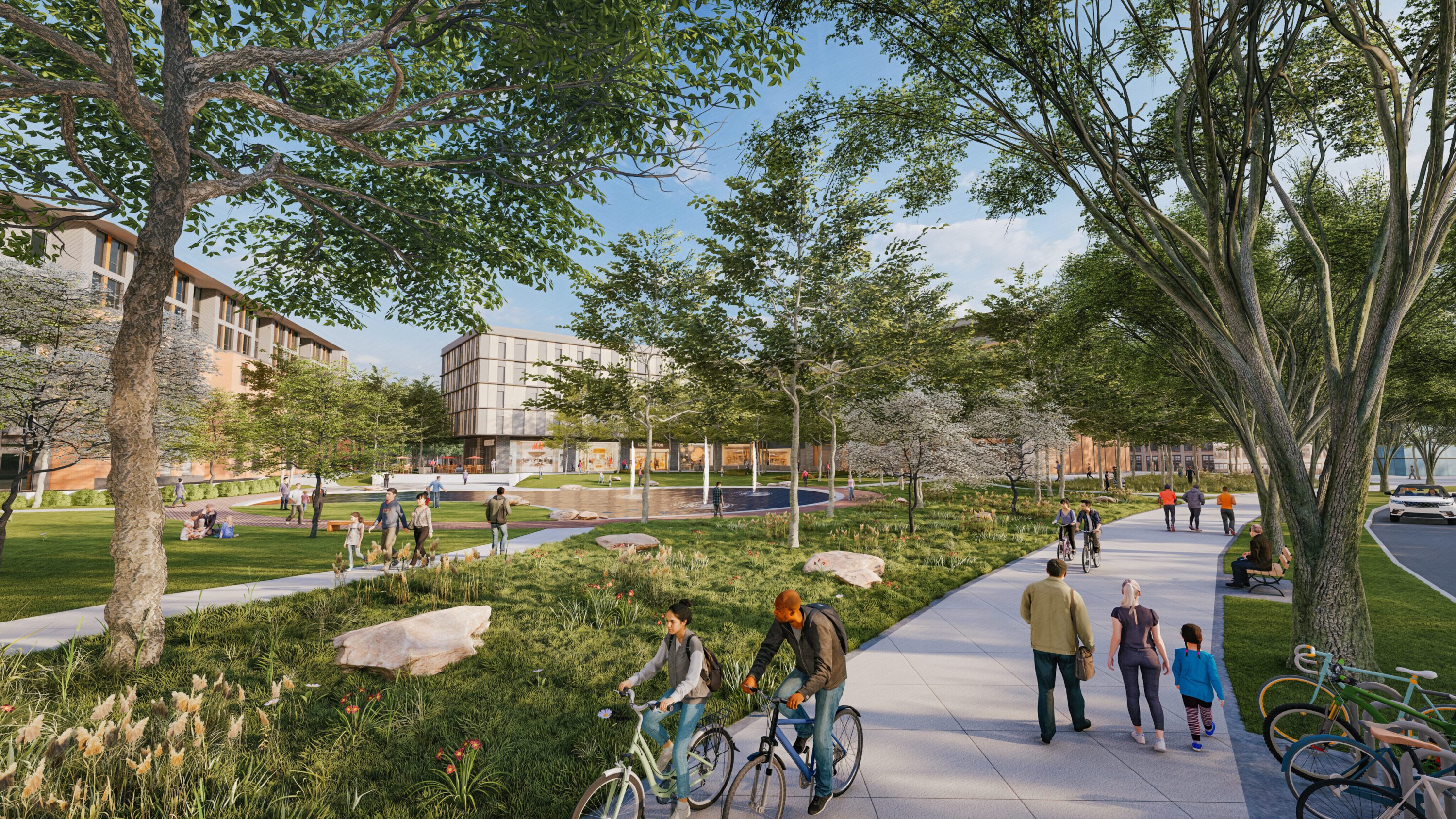 People walking and biking at town Center green space with bike paths and pond