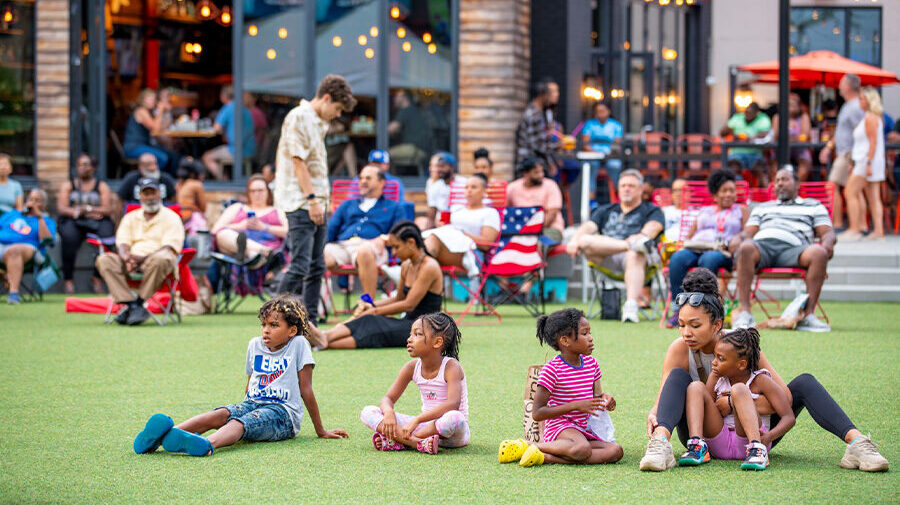 family with kids sitting in green space at Atlantic Station