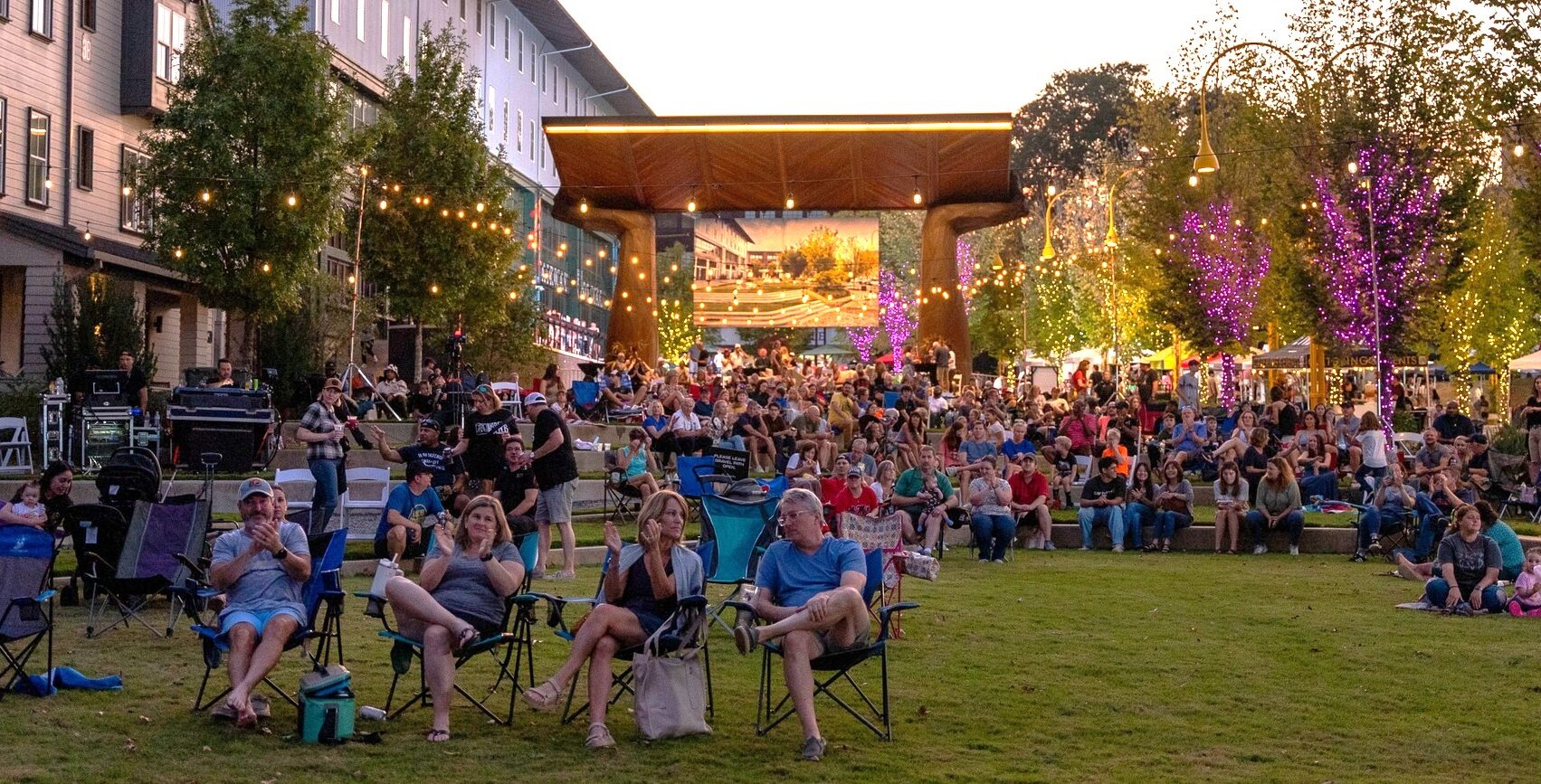 large group seated in Town at Trilith with lights in trees