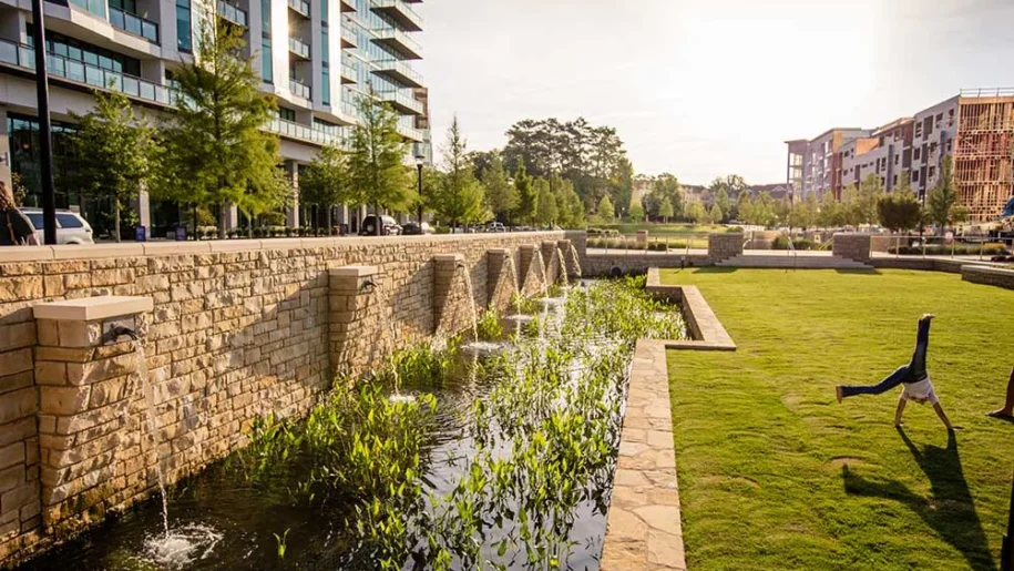 girl doing cartwheel next to water feature at Marie Sims Park