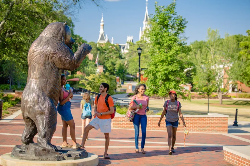 Mercer University Bear Statue with people walking on brick walkway