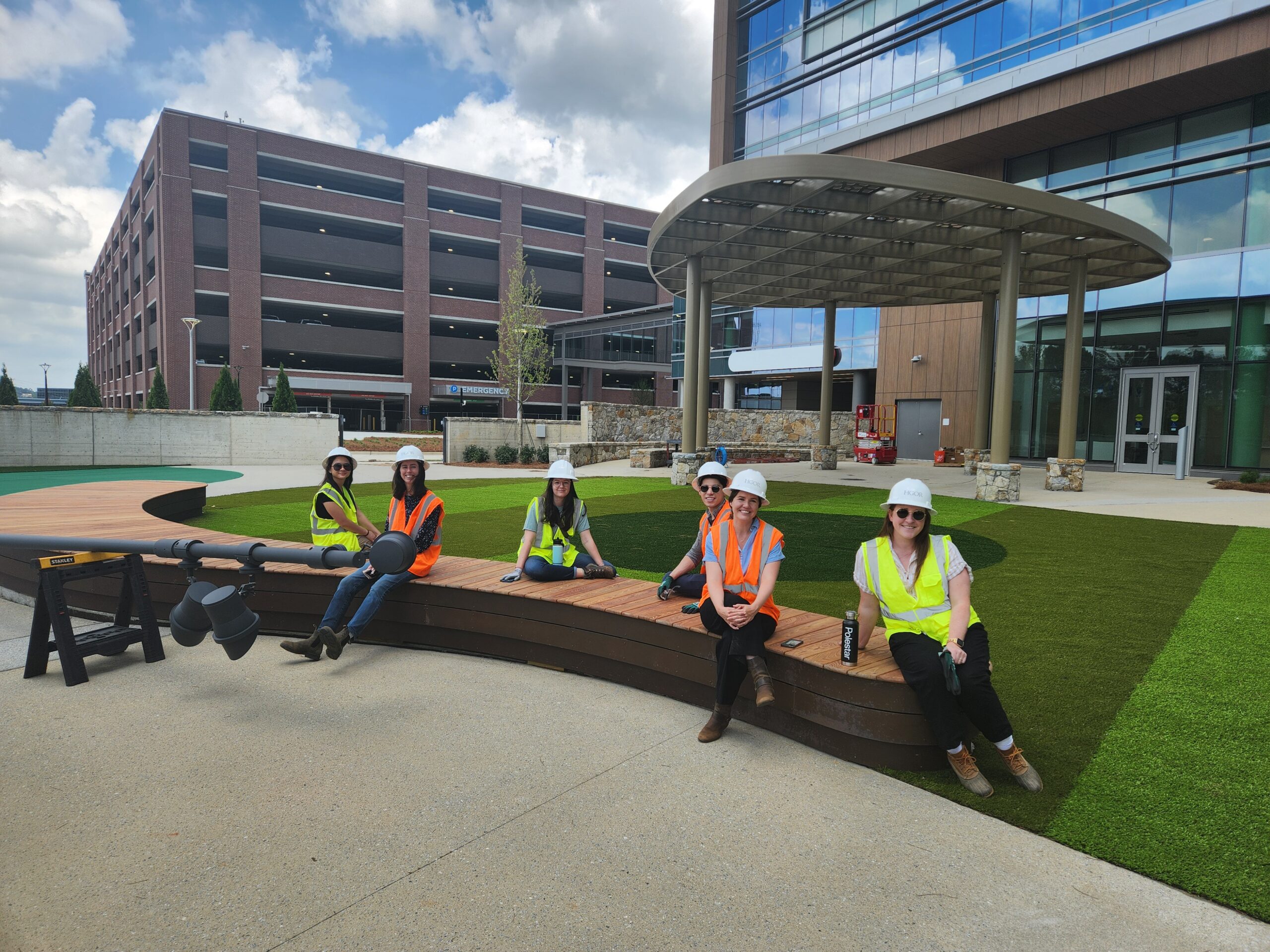 group of people in safety vests and hard hats in outdoor green space