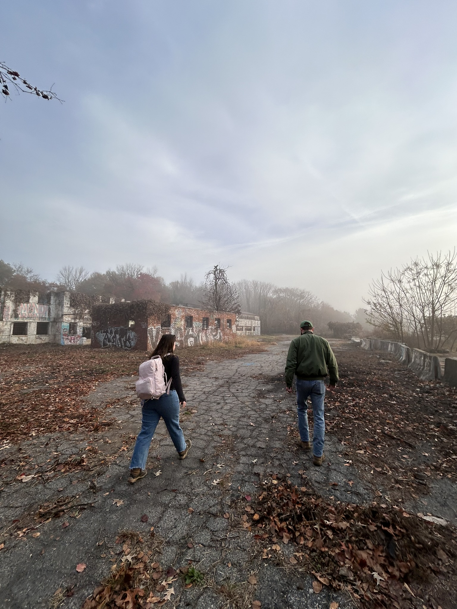 Two people walking in foggy abandoned area